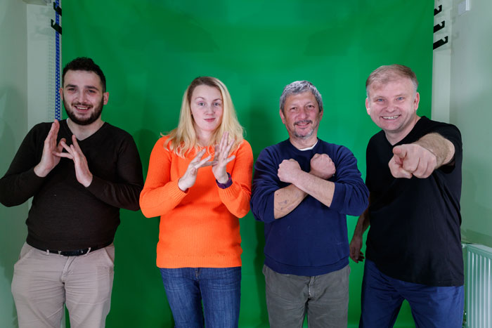 signing 'Jesus Loves You' in Romanian Sign Language